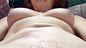 Quirky sexy fun hippy stepmom plays with her boobs and belly whilst exercising on a static bike